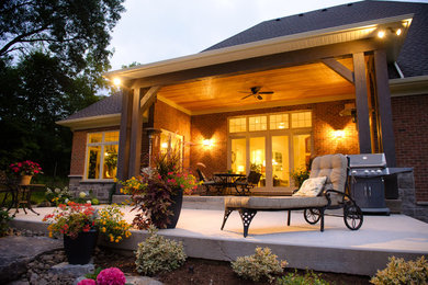 Diseño de patio de estilo americano de tamaño medio en patio trasero y anexo de casas con adoquines de piedra natural