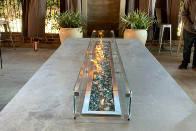 Large urban concrete patio photo in Other with a fire pit and a roof extension