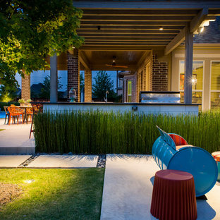 Esempio di un grande patio o portico boho chic dietro casa con pavimentazioni in cemento e una pergola