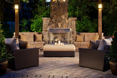 Inspiration for a large traditional back patio in Denver with a fire feature, brick paving and a pergola.