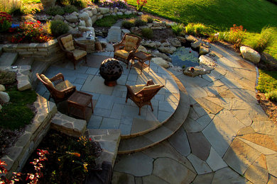 Mid-sized transitional backyard stone patio photo in New York with a fire pit and no cover
