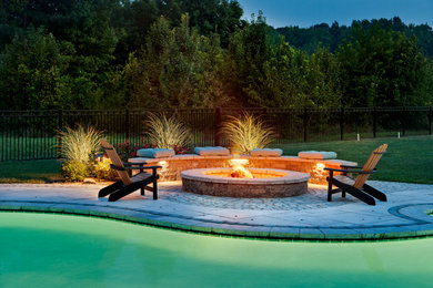 Example of a huge classic backyard concrete patio design in Charlotte with a fire pit