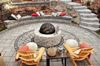 Foto de patio de estilo americano grande sin cubierta en patio trasero con brasero y adoquines de piedra natural