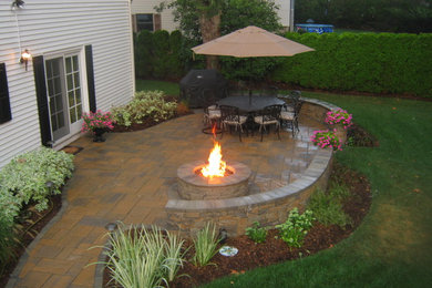 Mid-sized elegant backyard tile patio photo in New York with no cover and a fire pit