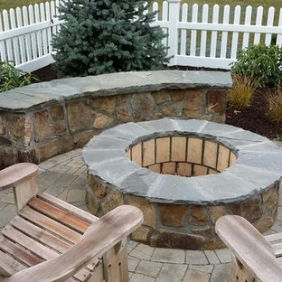 Esempio di un patio o portico stile americano di medie dimensioni e dietro casa con un focolare, pavimentazioni in pietra naturale e nessuna copertura