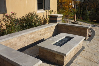 Inspiration for a backyard brick patio remodel in Milwaukee with a fire pit