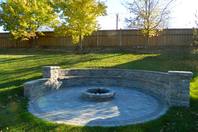 Example of a trendy concrete paver patio design in Minneapolis with a fire pit