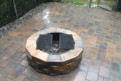 Patio - mid-sized traditional backyard brick patio idea in Bridgeport with a fire pit and no cover