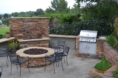 Example of a mid-sized classic backyard stone patio kitchen design in Denver with no cover