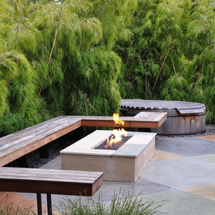Idee per un patio o portico etnico con un focolare e lastre di cemento