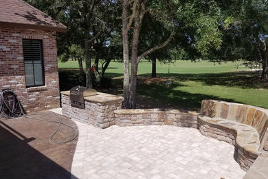 Large transitional backyard stone patio photo in Miami with a fire pit and no cover