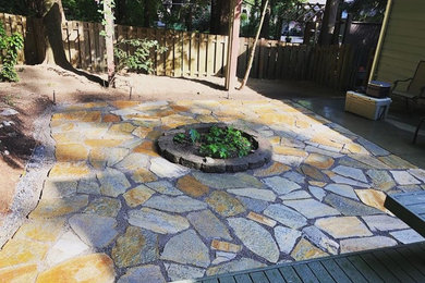 Minimalist backyard stone patio photo in Seattle with a fire pit