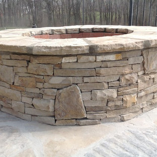 Ispirazione per un patio o portico american style di medie dimensioni e dietro casa con un focolare e pavimentazioni in pietra naturale