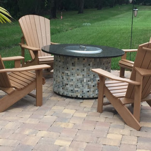 Immagine di un patio o portico di medie dimensioni e dietro casa con un focolare, pavimentazioni in cemento e nessuna copertura