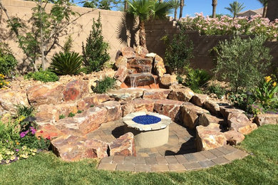 Mid-sized elegant backyard brick patio photo in Las Vegas with a fire pit and no cover