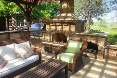 Mid-sized southwest backyard stone patio photo in Dallas with a fire pit and a pergola