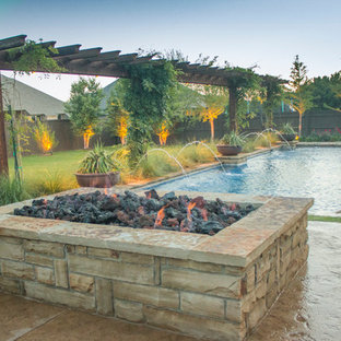 Esempio di un patio o portico stile americano di medie dimensioni e dietro casa con un focolare, lastre di cemento e una pergola