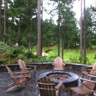 Foto di un patio o portico american style dietro casa e di medie dimensioni con un focolare, pavimentazioni in pietra naturale e nessuna copertura