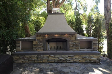Back patio in Los Angeles with a fire feature and natural stone paving.