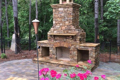 Großer, Unbedeckter Uriger Patio hinter dem Haus mit Feuerstelle und Natursteinplatten in Atlanta