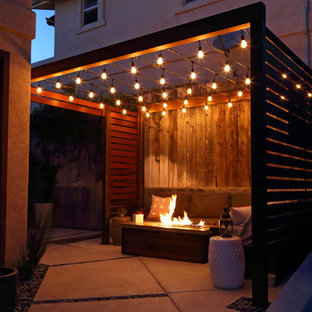 Photo of a small modern courtyard patio in San Luis Obispo with a fire feature, concrete slab and a pergola.