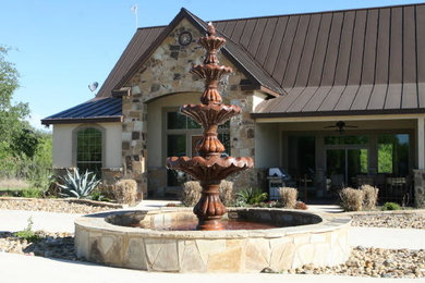 Ejemplo de patio de estilo americano grande en patio trasero con adoquines de piedra natural