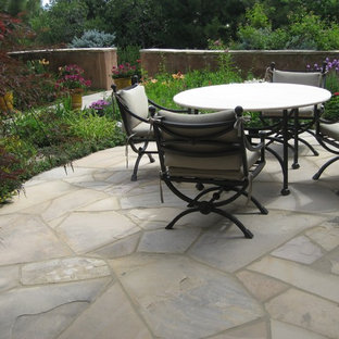 Immagine di un patio o portico boho chic di medie dimensioni e in cortile con un giardino in vaso, pavimentazioni in pietra naturale e nessuna copertura