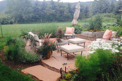 Ejemplo de patio tradicional grande sin cubierta en patio trasero con adoquines de piedra natural y jardín de macetas