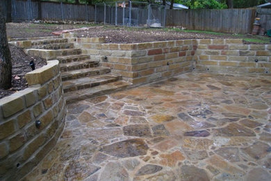Modelo de patio tradicional grande en patio trasero con adoquines de piedra natural