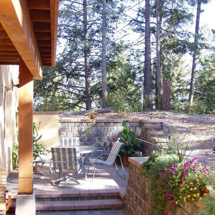 Ispirazione per un piccolo patio o portico eclettico in cortile con pavimentazioni in mattoni e una pergola