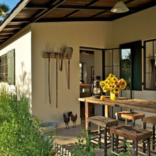 Idee per un patio o portico country nel cortile laterale con pavimentazioni in cemento e un tetto a sbalzo