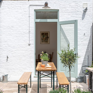 Romantic back patio in London with a potted garden and no cover.