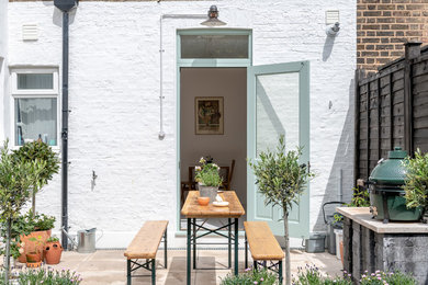 Unbedeckter Shabby-Style Patio hinter dem Haus mit Kübelpflanzen in London