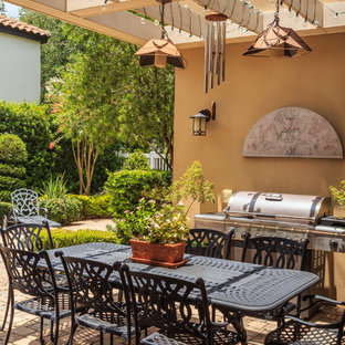 Idee per un patio o portico mediterraneo dietro casa con pavimentazioni in mattoni e una pergola