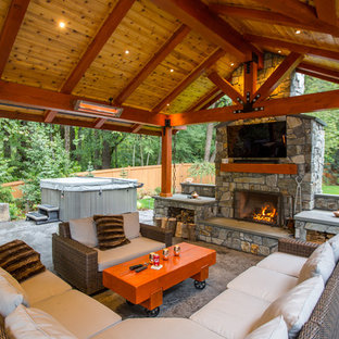 Immagine di un grande patio o portico stile americano dietro casa con lastre di cemento e un tetto a sbalzo