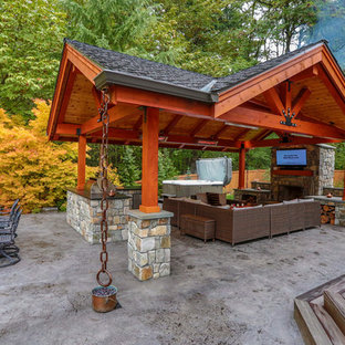 Ispirazione per un grande patio o portico american style dietro casa con lastre di cemento e un tetto a sbalzo