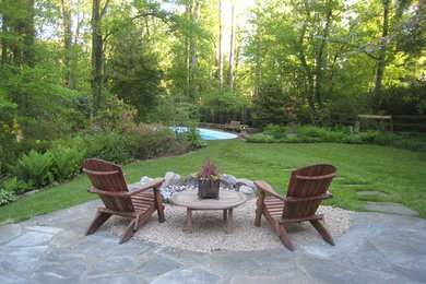 Inspiration for a large transitional backyard stone patio remodel in Philadelphia with a fire pit and no cover