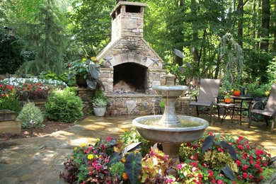 Imagen de patio tradicional sin cubierta en patio con fuente y adoquines de piedra natural