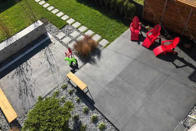 Idee per un patio o portico moderno dietro casa con fontane, lastre di cemento e una pergola