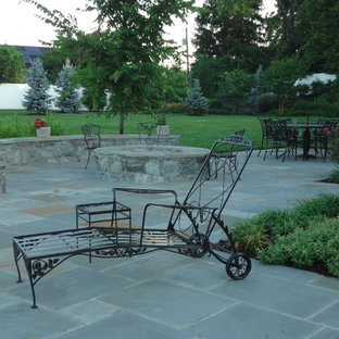 Idee per un grande patio o portico chic dietro casa con un focolare, piastrelle e nessuna copertura