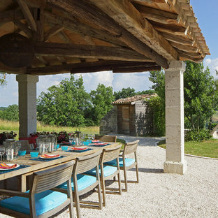 Idées déco pour une grande terrasse arrière avec du gravier et un gazebo ou pavillon.