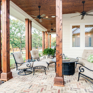 Idee per un grande patio o portico country davanti casa con un giardino in vaso, pavimentazioni in pietra naturale e un tetto a sbalzo