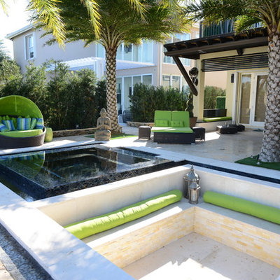 Example of a huge trendy backyard stone patio kitchen design in Miami with a pergola