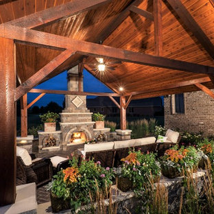 Esempio di un grande patio o portico design dietro casa con un caminetto, pavimentazioni in mattoni e un gazebo o capanno