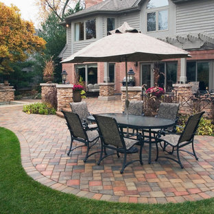 Esempio di un patio o portico eclettico di medie dimensioni e dietro casa con fontane, pavimentazioni in cemento e una pergola