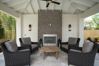 Ejemplo de patio clásico de tamaño medio en patio trasero y anexo de casas con chimenea y adoquines de piedra natural