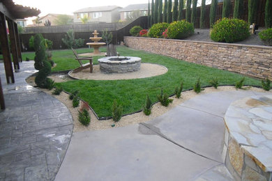 Diseño de patio clásico renovado de tamaño medio en patio trasero con brasero y adoquines de piedra natural