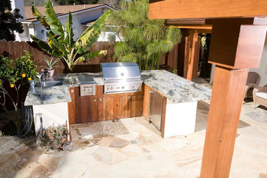 Mid-sized arts and crafts backyard stone patio kitchen photo in Santa Barbara with a pergola