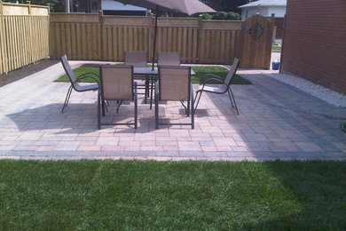 Mid-sized side yard stone patio photo in Toronto with no cover