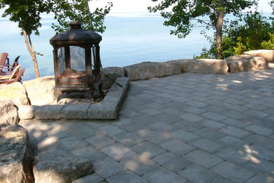 Inspiration for a large backyard concrete paver patio fountain remodel in Toronto with no cover
